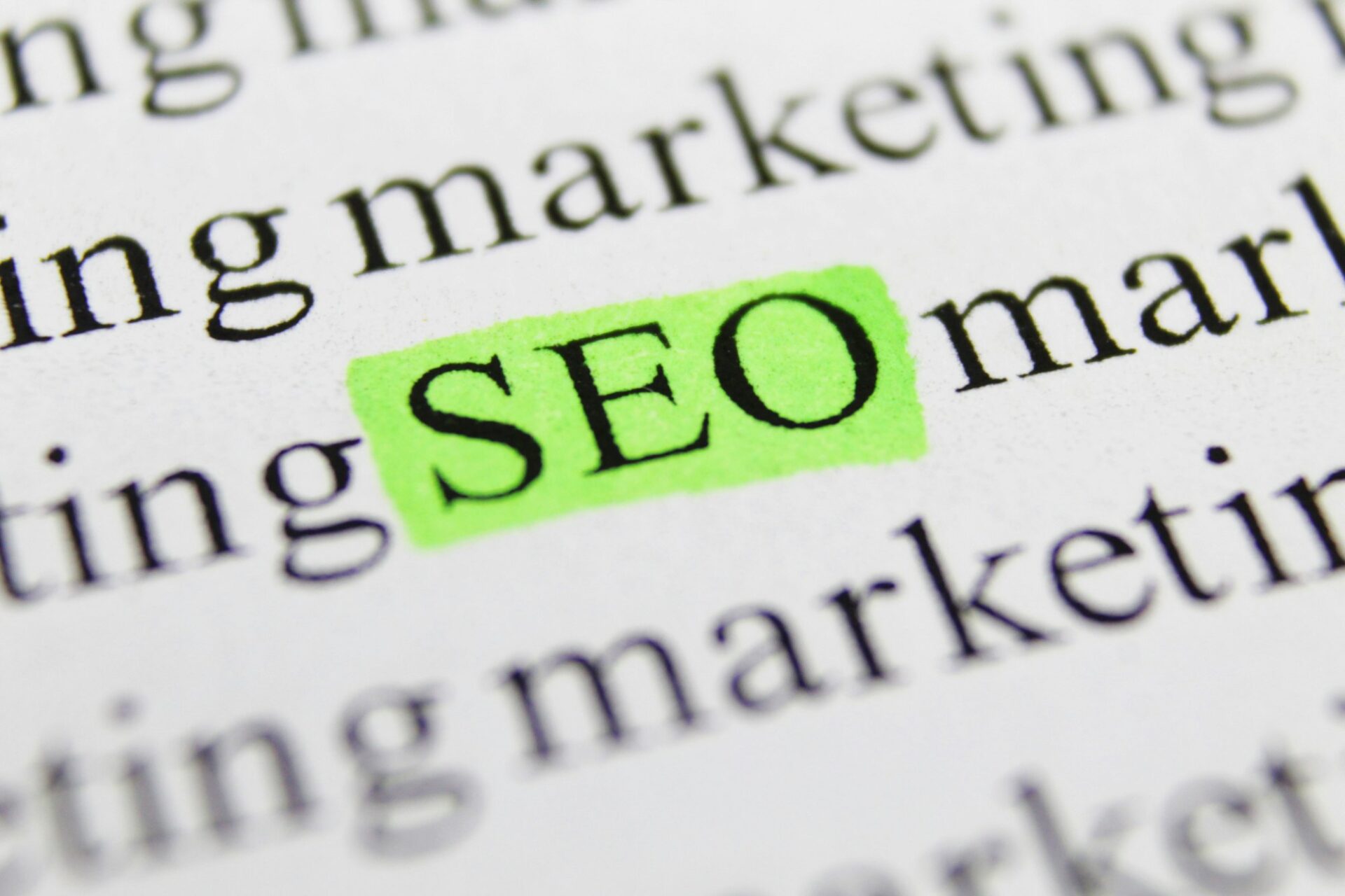 Close-up of text with SEO highlighted in green, emphasizing search engine optimization in marketing.