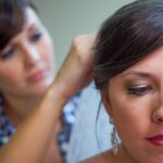 Bride getting her hair styled, focused on elegant earrings and makeup, preparing for her wedding day.