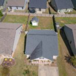 Aerial view of suburban homes with fenced yards and driveways on Sidestreet, showcasing residential neighborhood layout.