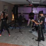 Live band performance in an intimate venue with lead singer and guitarists. Energetic indoor music event.