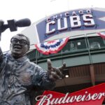 Statue of announcer in front of Wrigley Field, home of the Chicago Cubs, with celebratory banners and signs.